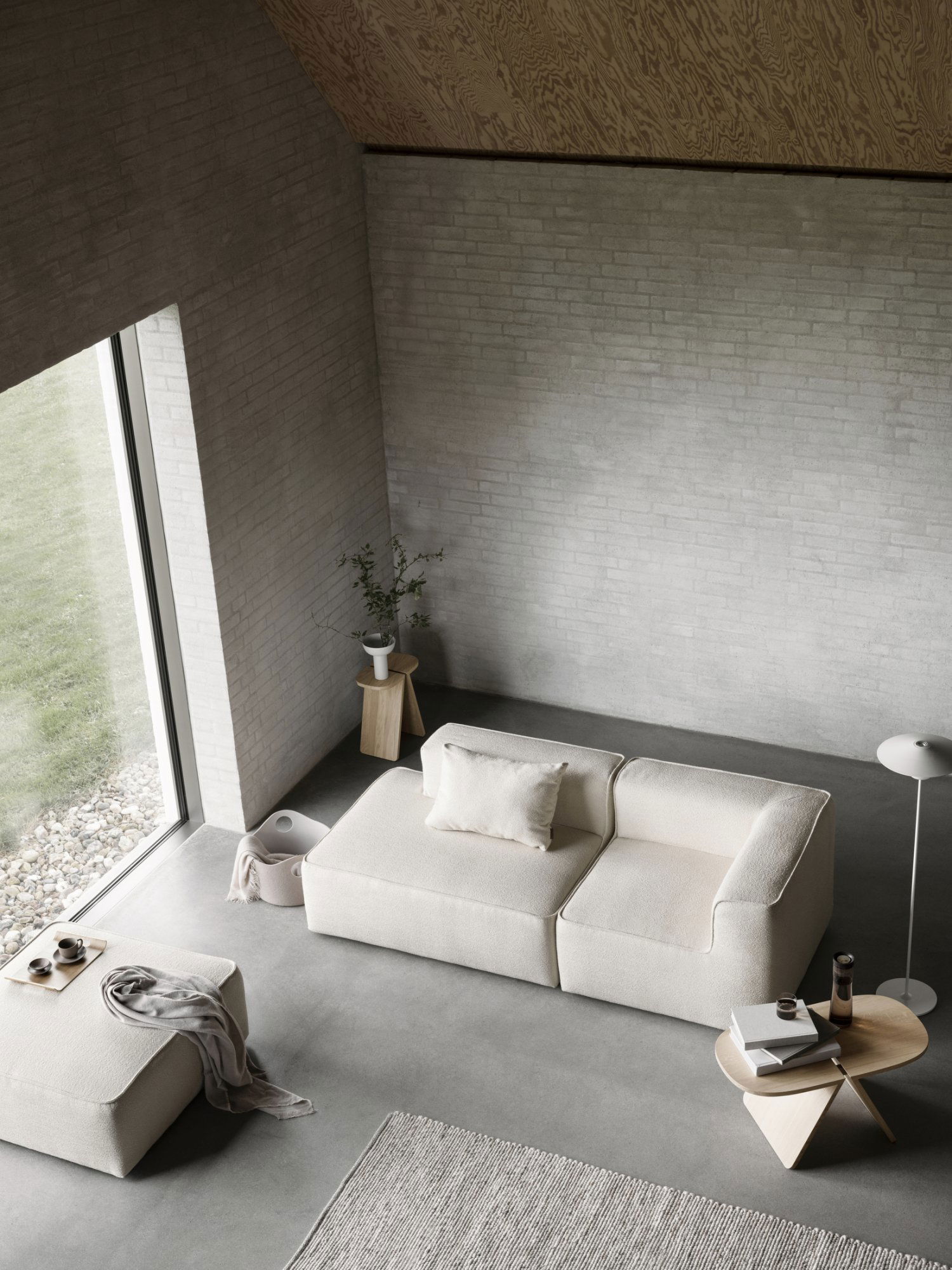 Modern living room featuring a minimalist beige sofa and natural light from large windows.