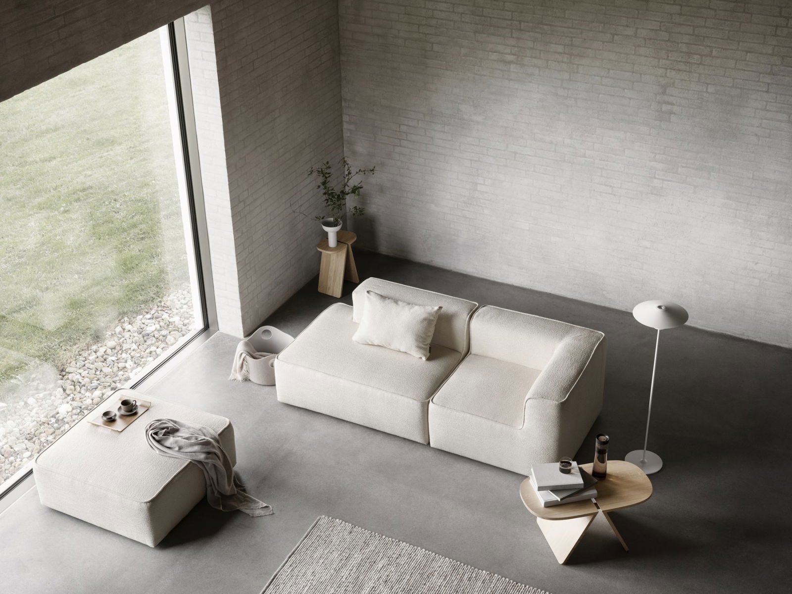 Modern minimalist living room with a cozy white sofa, wooden table, and stylish decor.