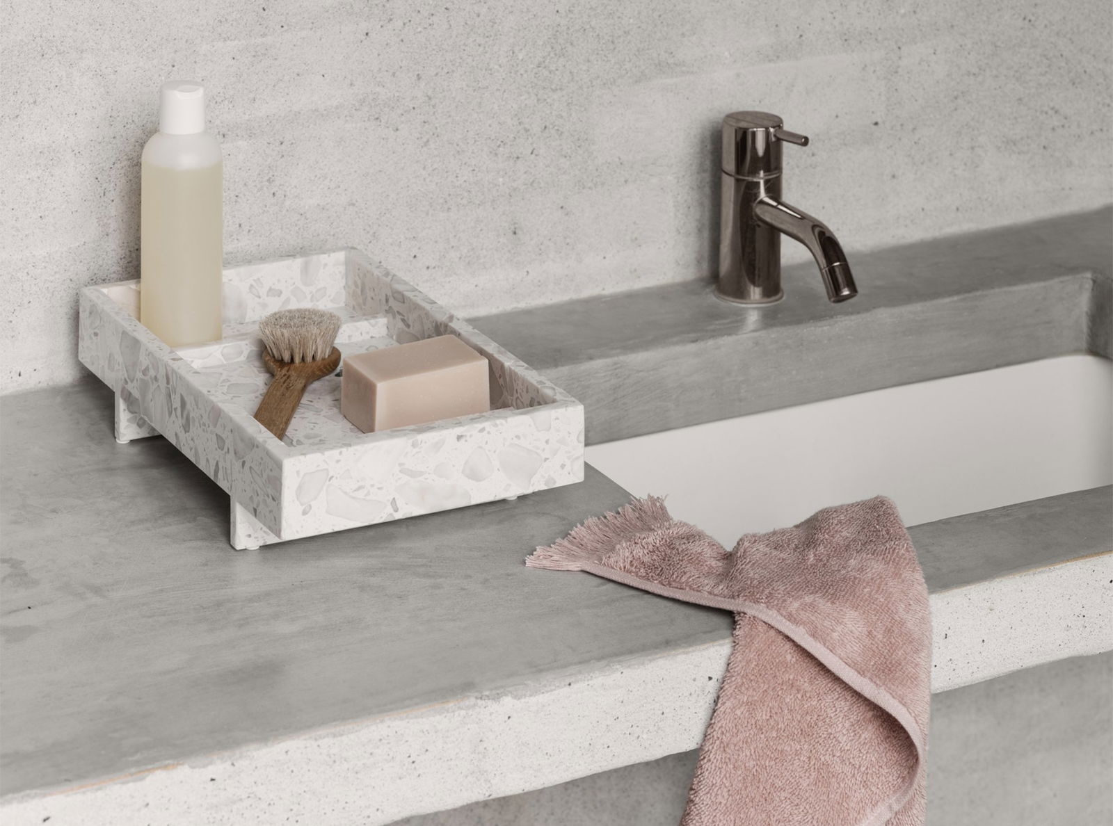 Stylish bathroom counter with soap, brush, and a soft towel for a modern look.