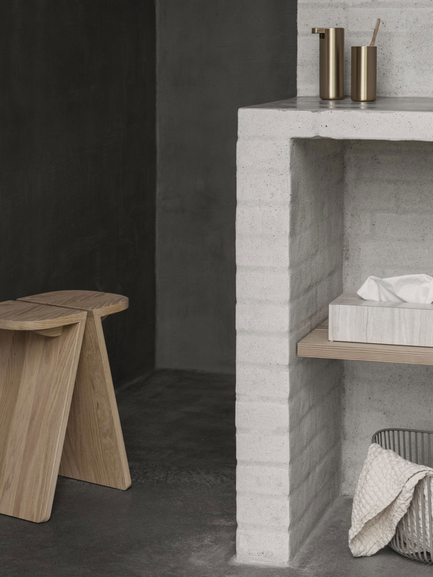 Elegant minimalist living space featuring a concrete shelf and wooden stool.