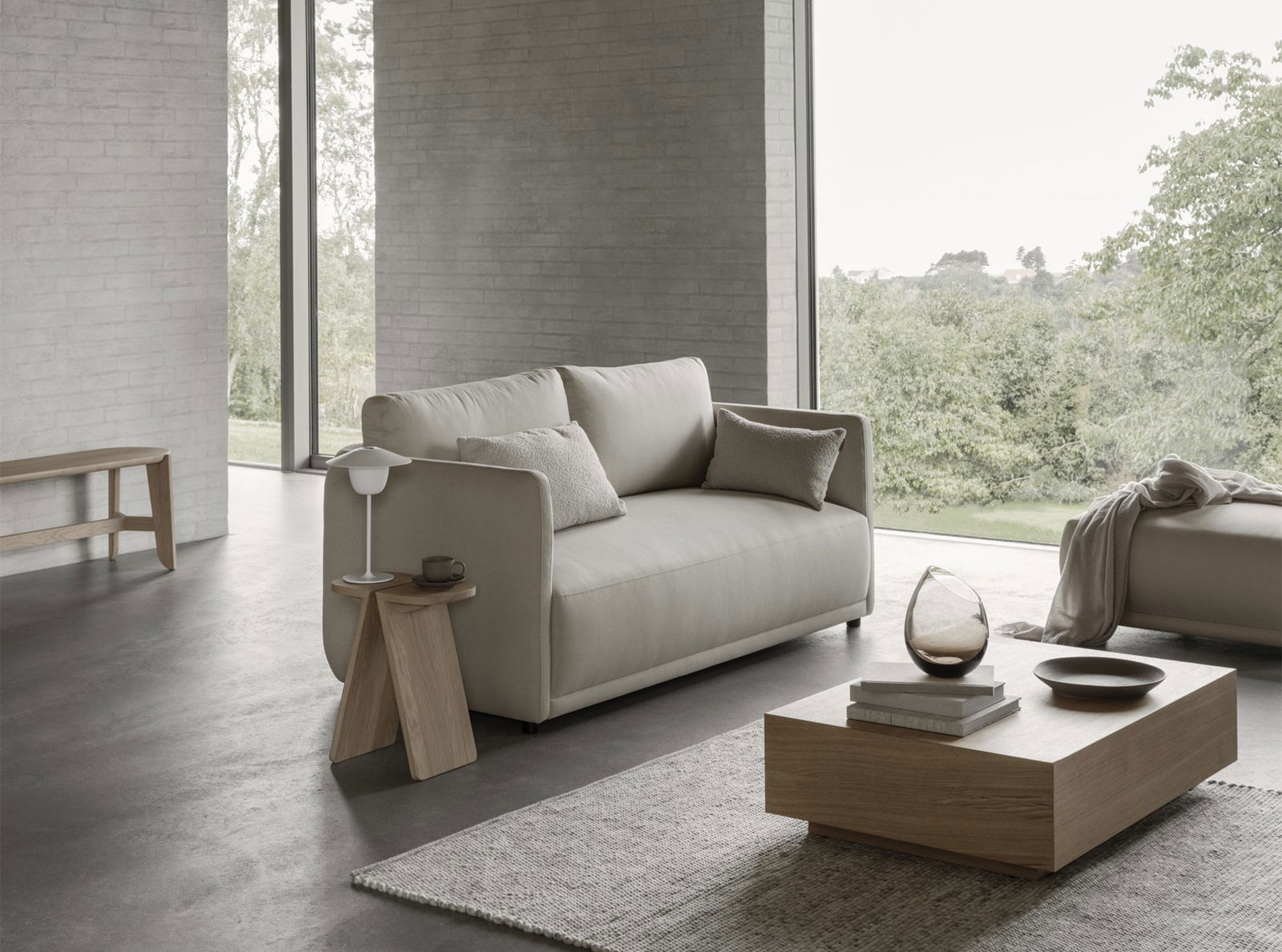 Moderner beiger Sofa mit dekorativen Kissen in einem stilvollen, minimalistischen Wohnzimmer.