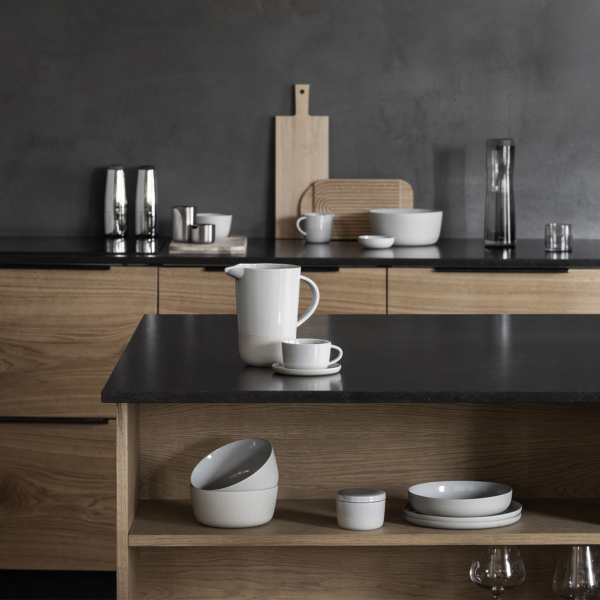 Modern kitchen interior with minimalist dishware and sleek wooden cabinetry.