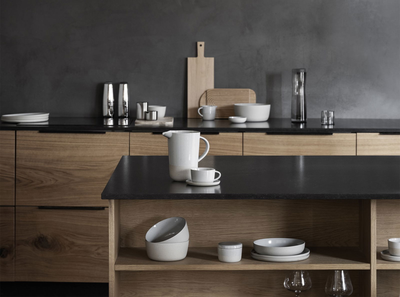 Modern kitchen interior with minimalist dishware and sleek wooden cabinetry.