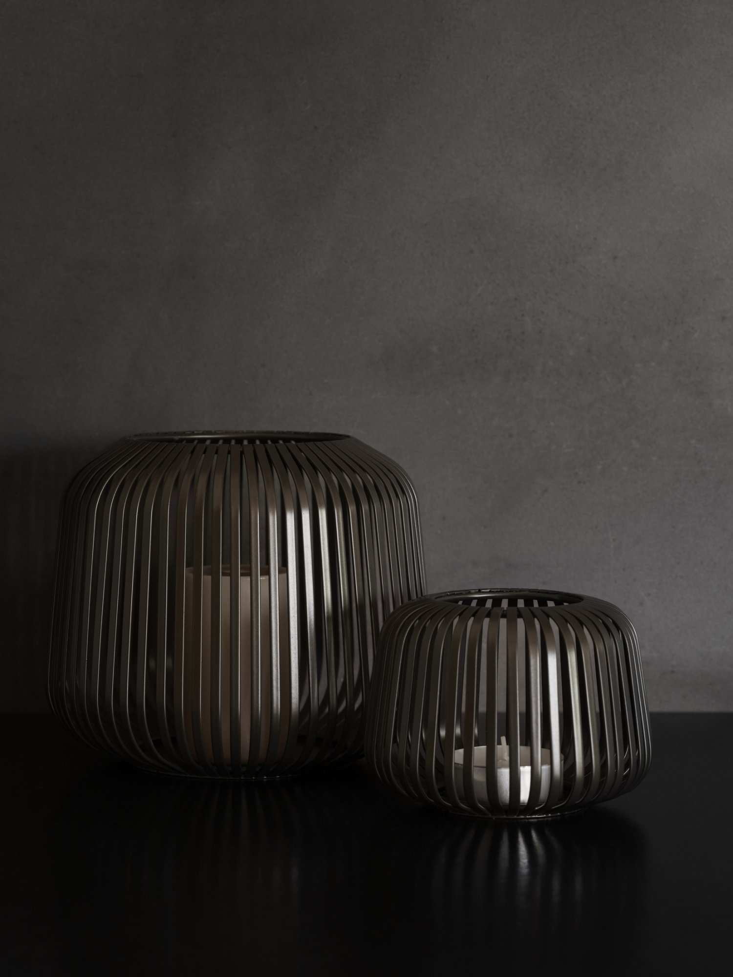 Stylische schwarze Metalllaternen, die einen dunklen, minimalistischen Hintergrund beleuchten.