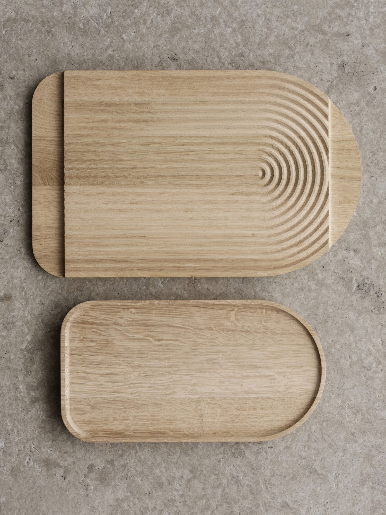 Zwei stilvolle Holzschneidebretter mit einzigartigen Formen und Texturen auf einer Steinoberfläche.