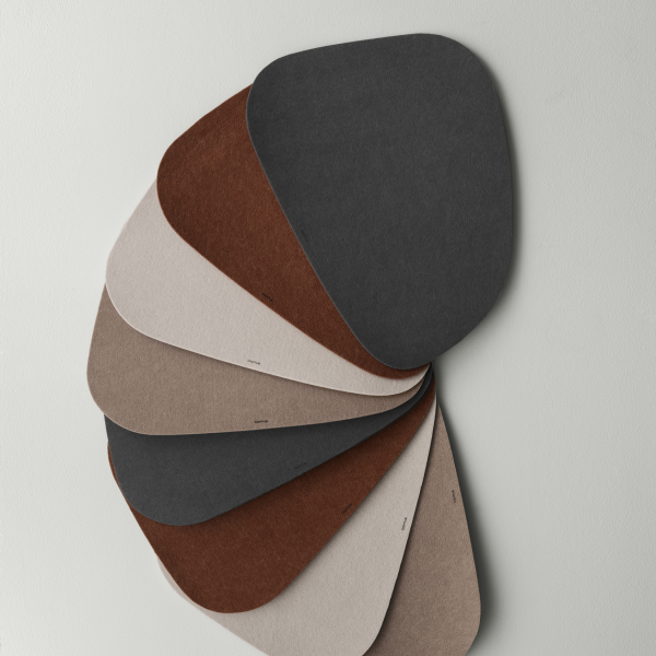 Colorful felt material swatches in various shapes and shades displayed on a wall.