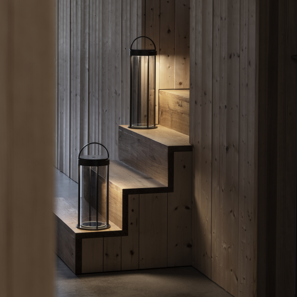 Moderne Holztreppe, die von stilvollen Laternen in einem gemütlichen Innenraum beleuchtet wird.