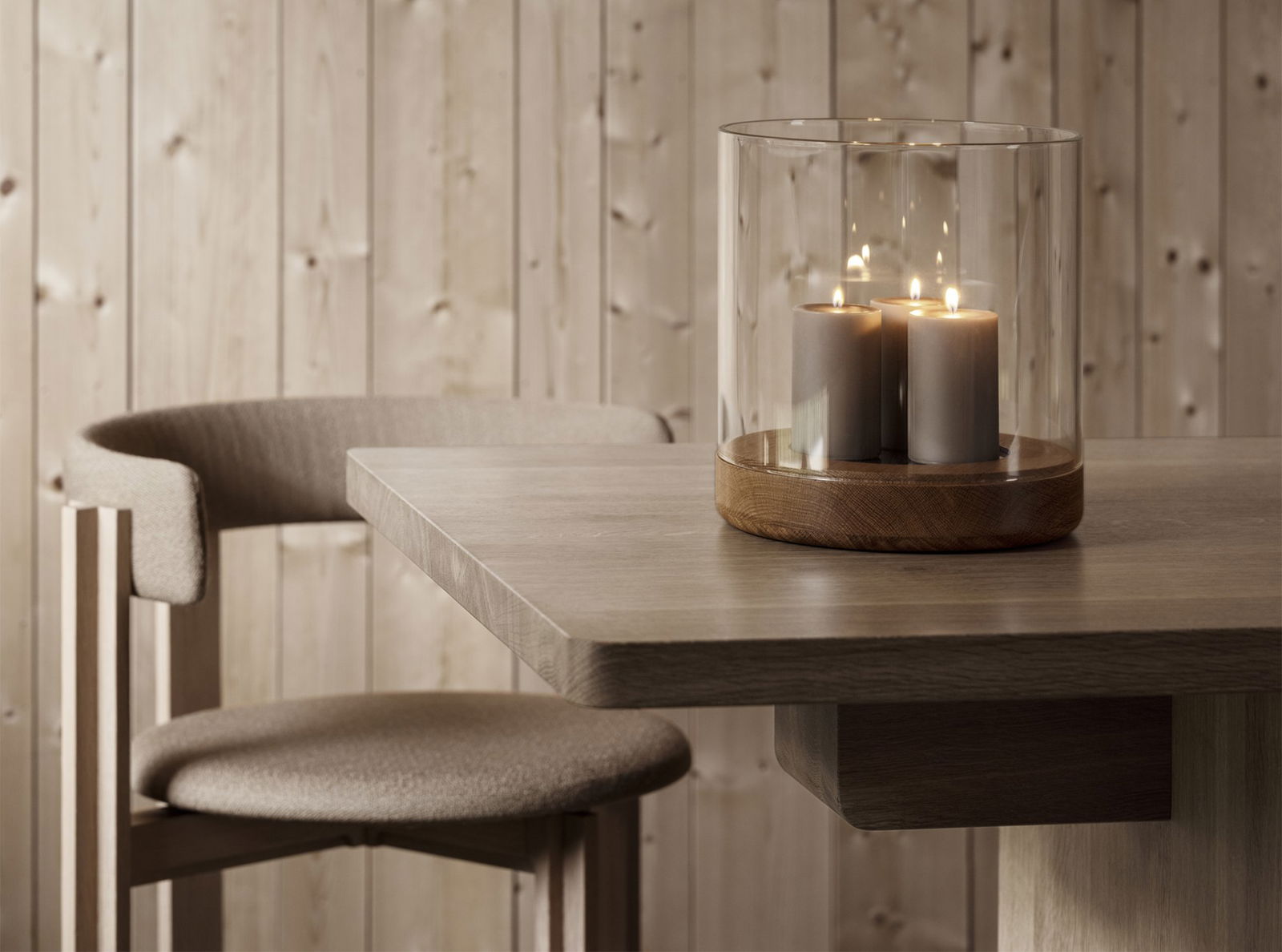 Kerzenarrangement auf einem Holztisch neben einem modernen Stuhl in einer gemütlichen Umgebung.