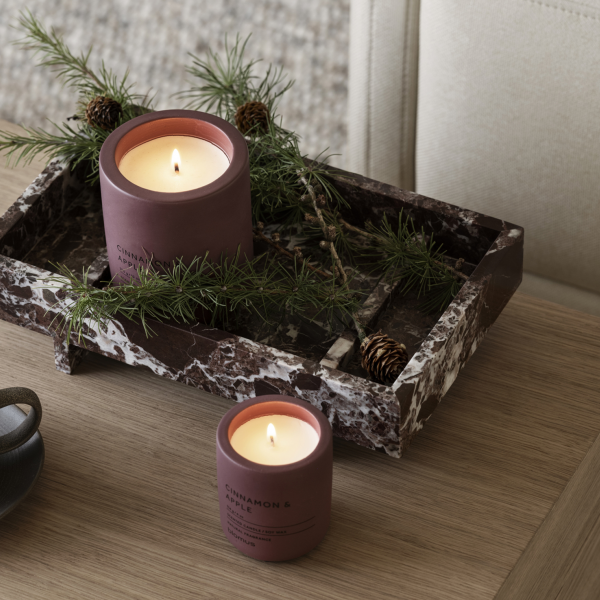Elegant candles with greenery on a stylish marble tray, creating a cozy ambiance.