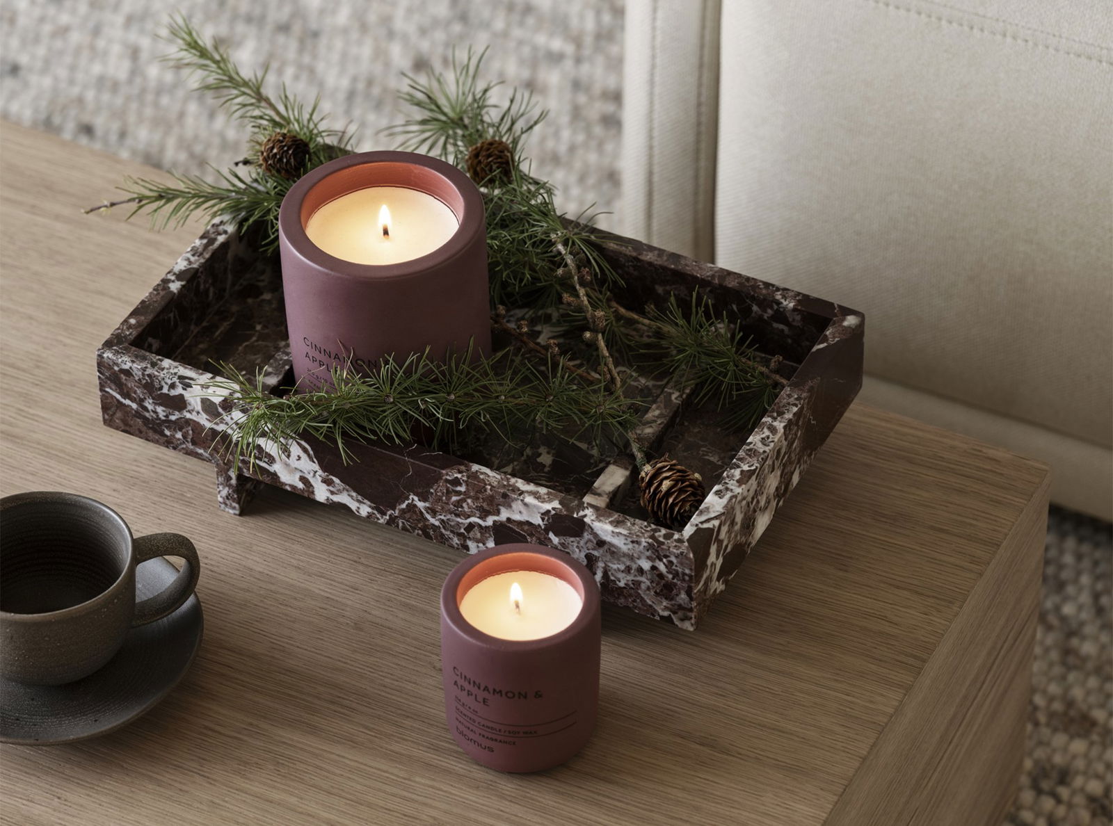 Elegant candles with greenery on a stylish marble tray, creating a cozy ambiance.