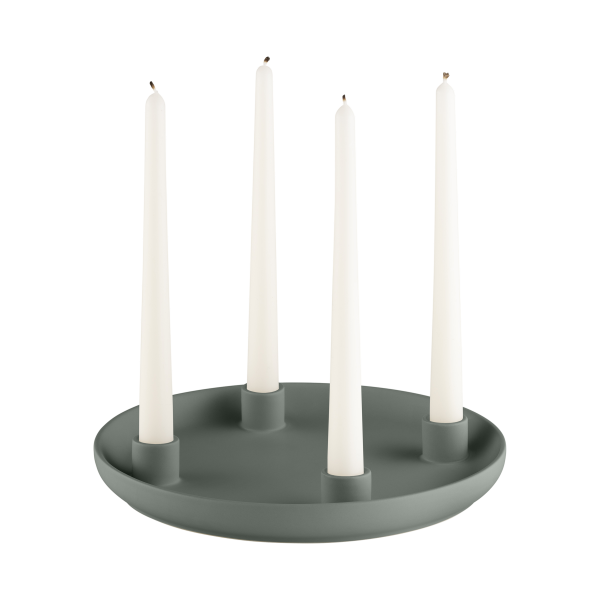 Elegant green candle holder with four tall white candles for a modern home decor.