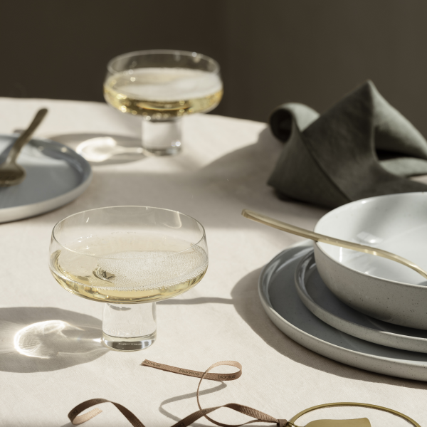Elegante Tischdekoration mit Champagnergläsern, eleganten Tellern und sanften Stoffservietten.