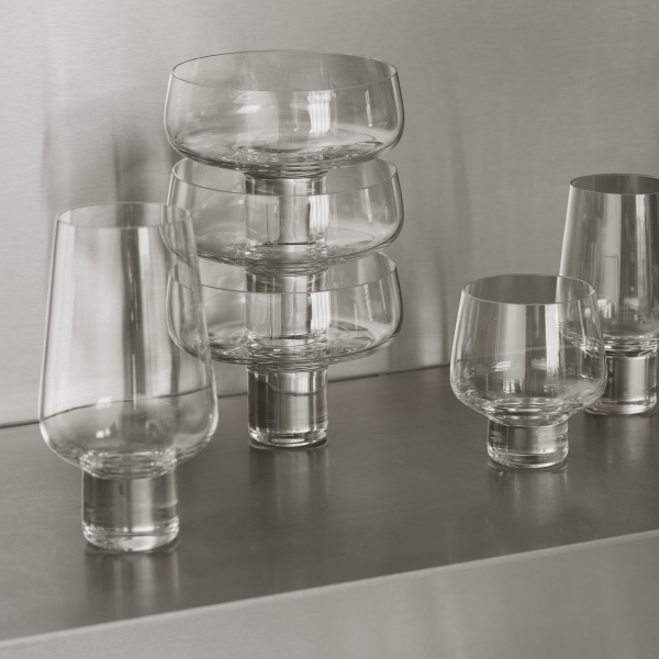 Elegantes gestapeltes Glasgeschirr auf einer schlanken metallischen Oberfläche für moderne Speise-Dekoration.