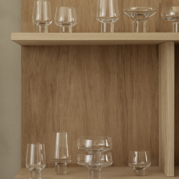 Elegantes Glaswaren, die auf minimalistischen Holzregalen ausgestellt sind.