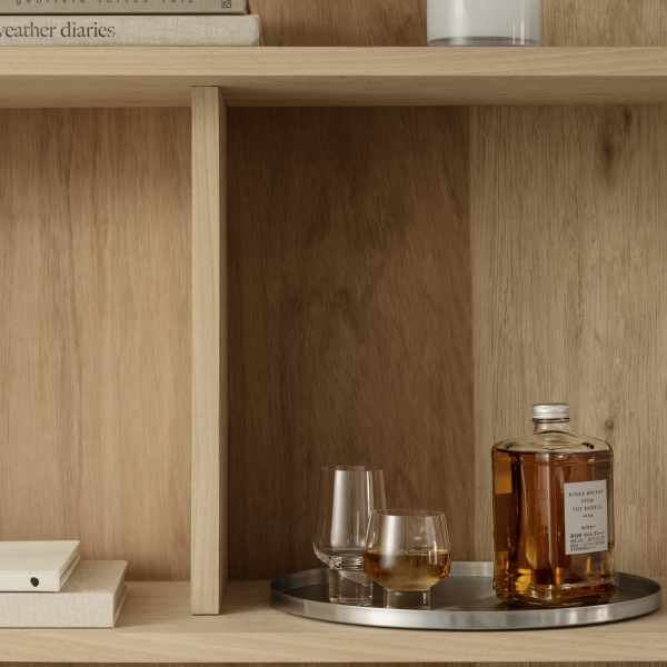 Stylish wooden shelf showcasing whiskey bottle and elegant glassware.