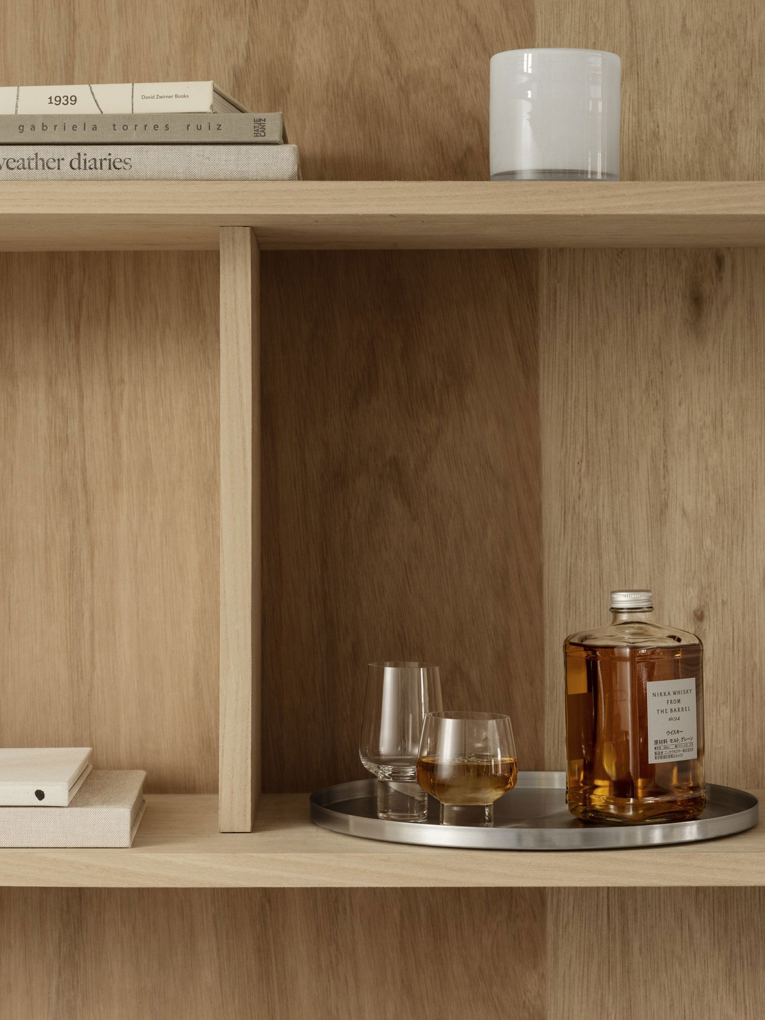 Stylish wooden shelf showcasing whiskey bottle and elegant glassware.