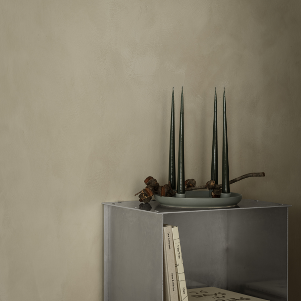 Modern decor featuring green candles and decorative items on a minimalist metal shelf.
