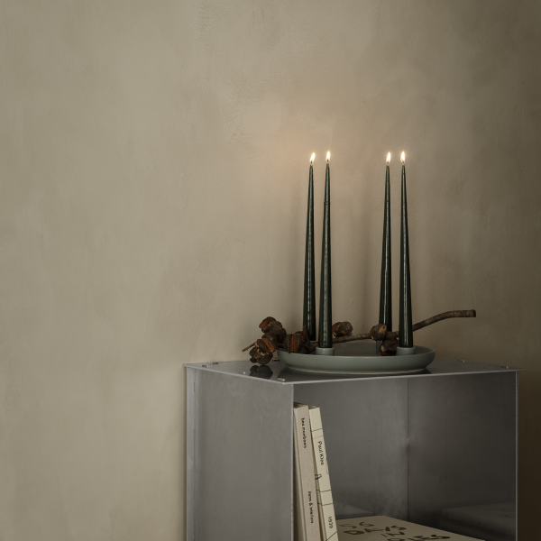 Elegant candle display with tall, dark candles and a minimalist gray shelf decor.