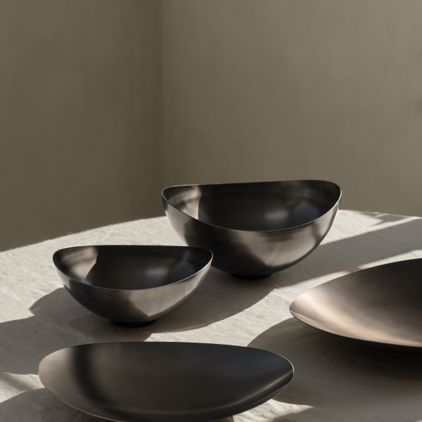 Moderne schwarze Metallschalen elegant auf einer hellen Tischdecke arrangiert.