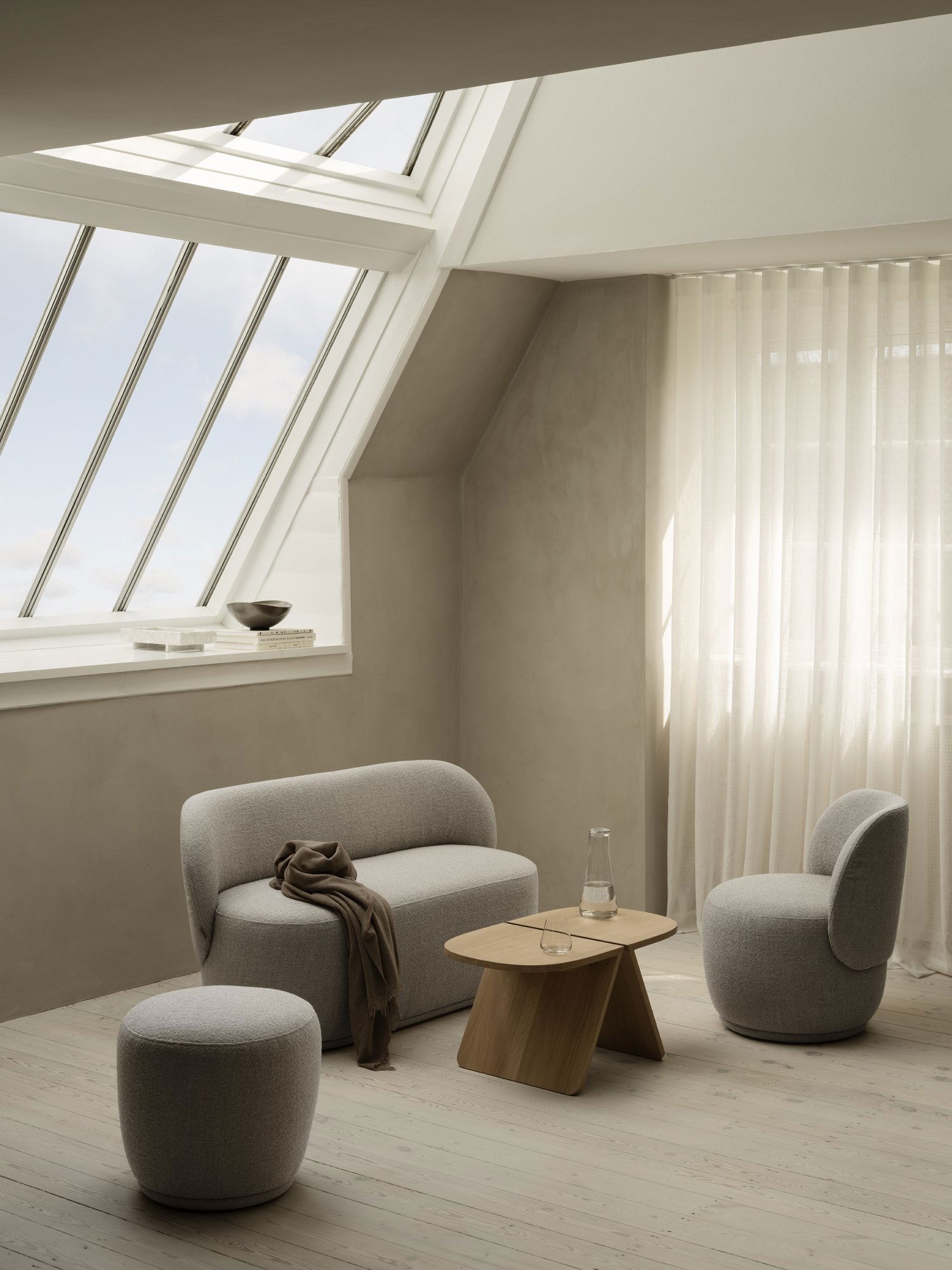Modern minimalist Wohnzimmer mit gemütlicher Möbeln, natürlichem Licht und sanften Texturen.