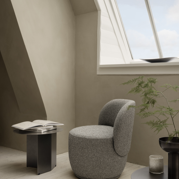Gemütliches modernes Interieur mit einem strukturierten Stuhl und minimalistischer Dekoration in der Nähe eines Dachfensters.