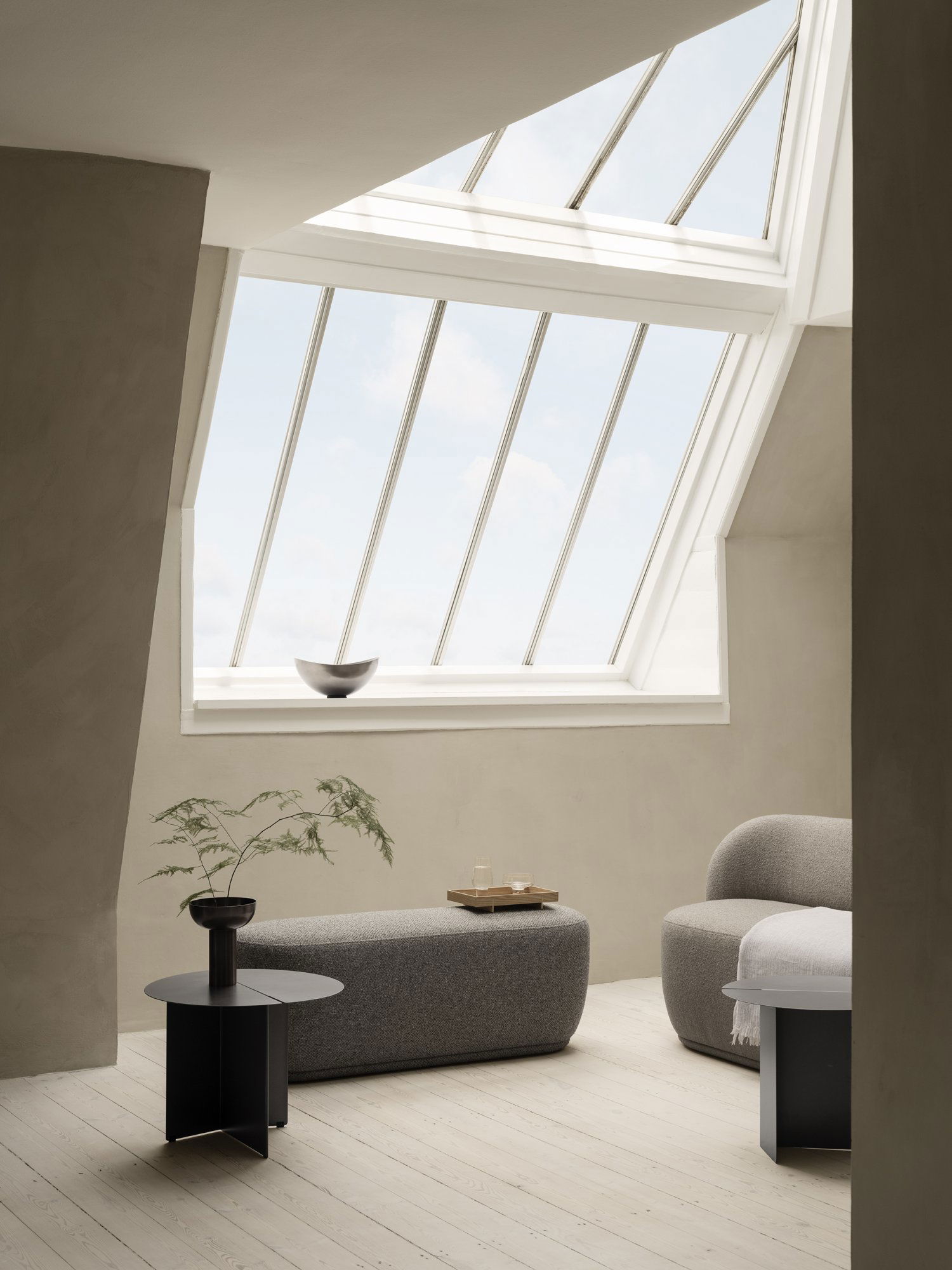 Moderner Wohnraum mit Oberlicht, gemütlichen Möbeln und minimalistischer Dekoration.