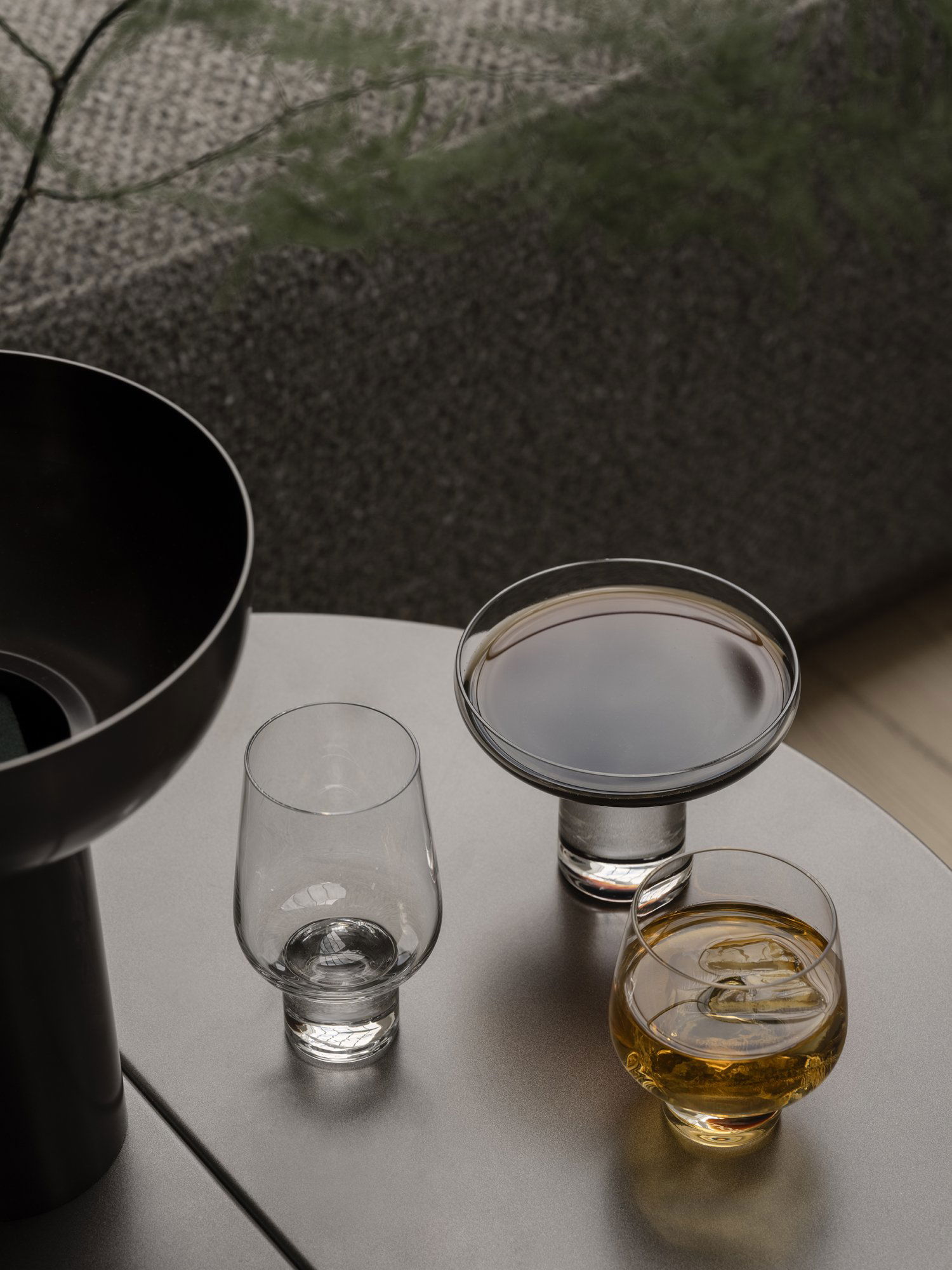 Elegant drinkware with assorted cocktails on a stylish table in a modern setting.