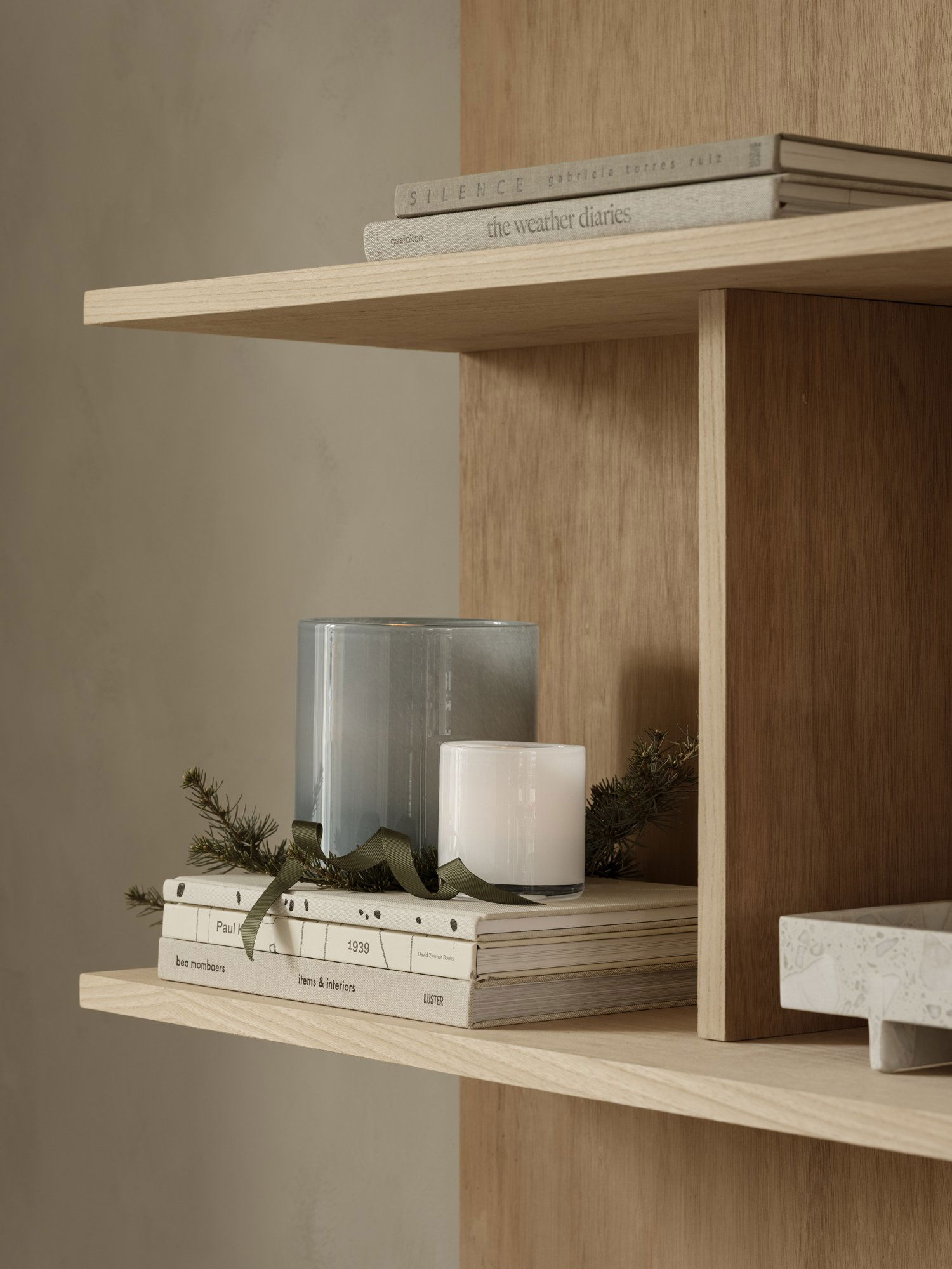 Stylish shelf with candles, books, and greenery for a cozy home decor ambiance.