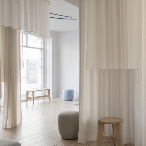 Minimalist interior featuring light curtains, wooden furniture, and a soft color palette.