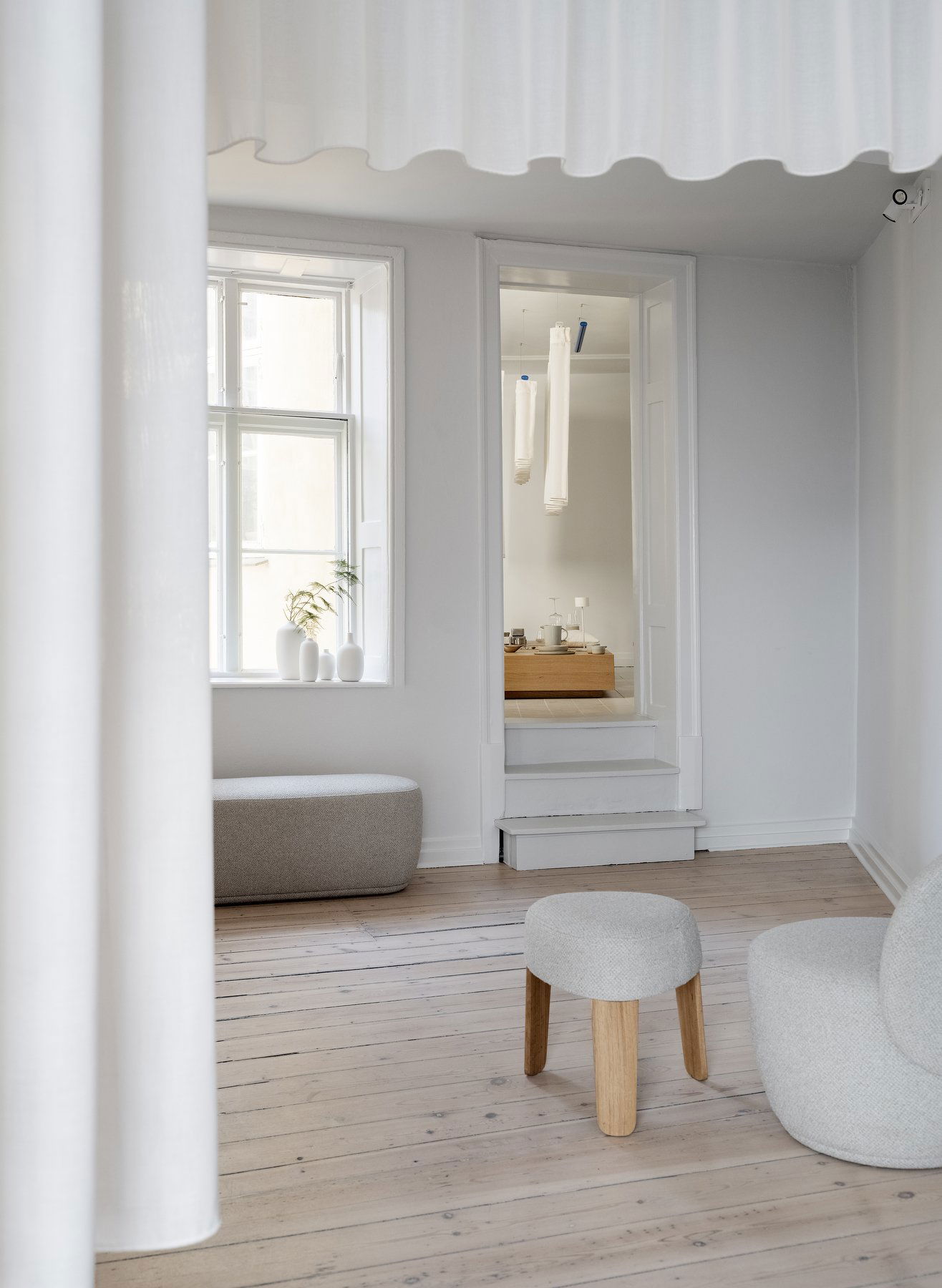 Minimalist interior featuring natural light and modern furniture in a serene setting.