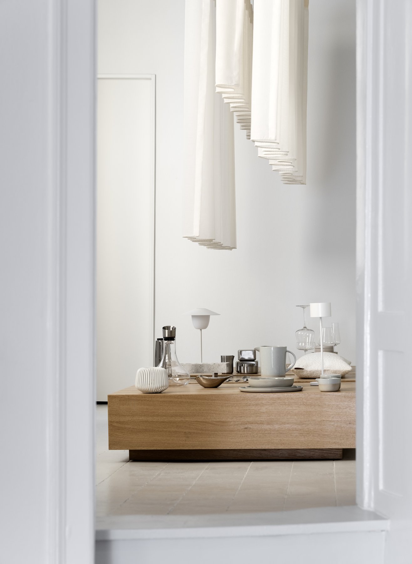 Moderner minimalistischer Innenraum mit einem Holztisch und eleganter Tischdekoration.