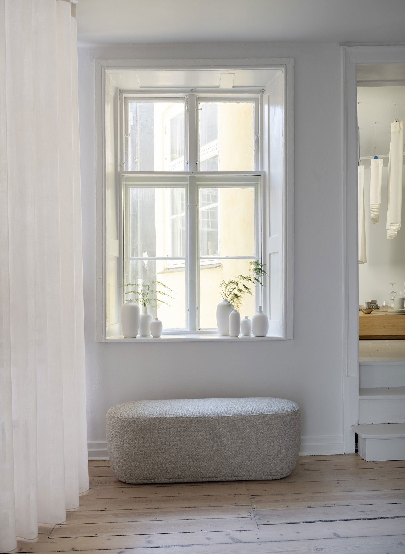 Bright interior with a minimalist window display and modern decor in a serene space.
