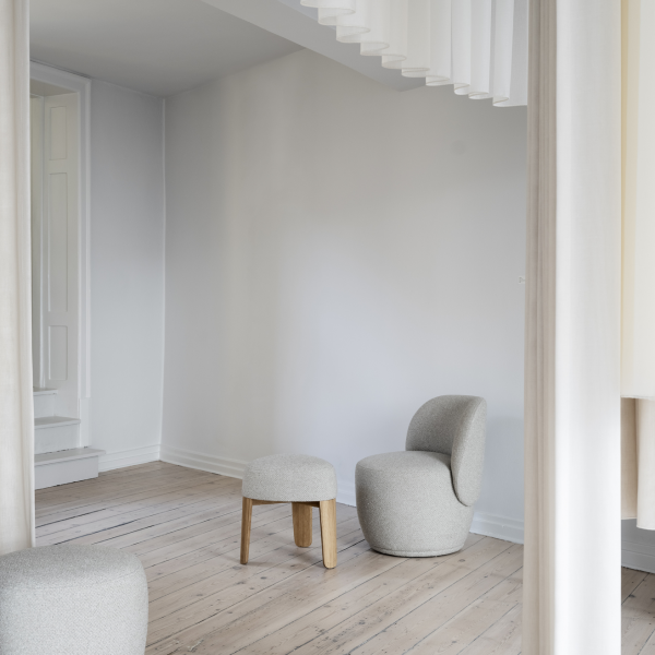 Modern minimalist living room with stylish gray seating and wooden accents.