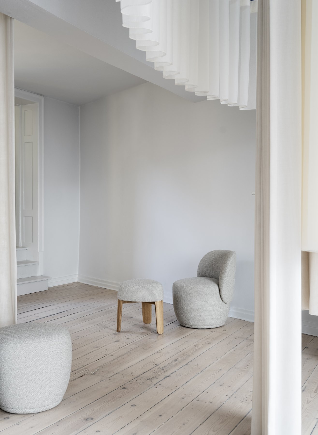 Modern minimalist living room with stylish gray seating and wooden accents.