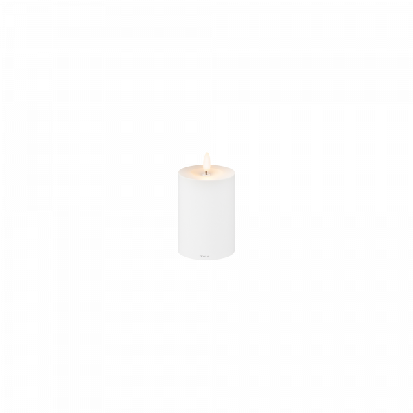 Weiße dekorative Kerze mit einer sanften Flamme auf einem minimalistischen Hintergrund.