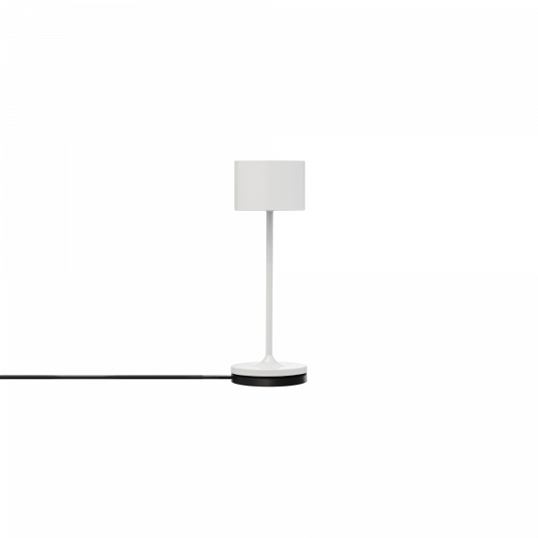 Moderne weiße Tischlampe mit einem zylindrischen Schirm und elegantem Design an einem schwarzen Kabel.