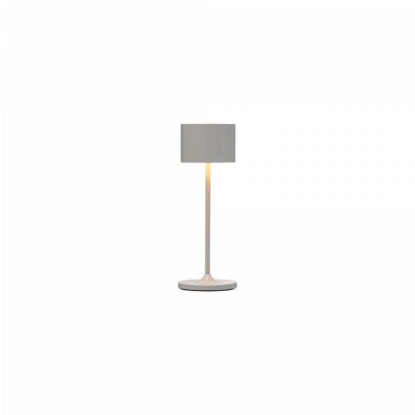 Moderne weiße Tischlampe mit einem zylindrischen Schirm und einem runden Fuß.