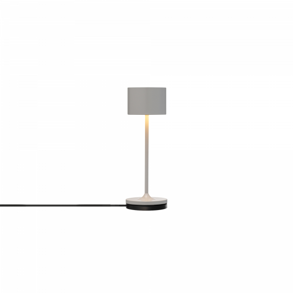 Moderne weiße Tischlampe mit einfachem Design und warmem Lichtschein.