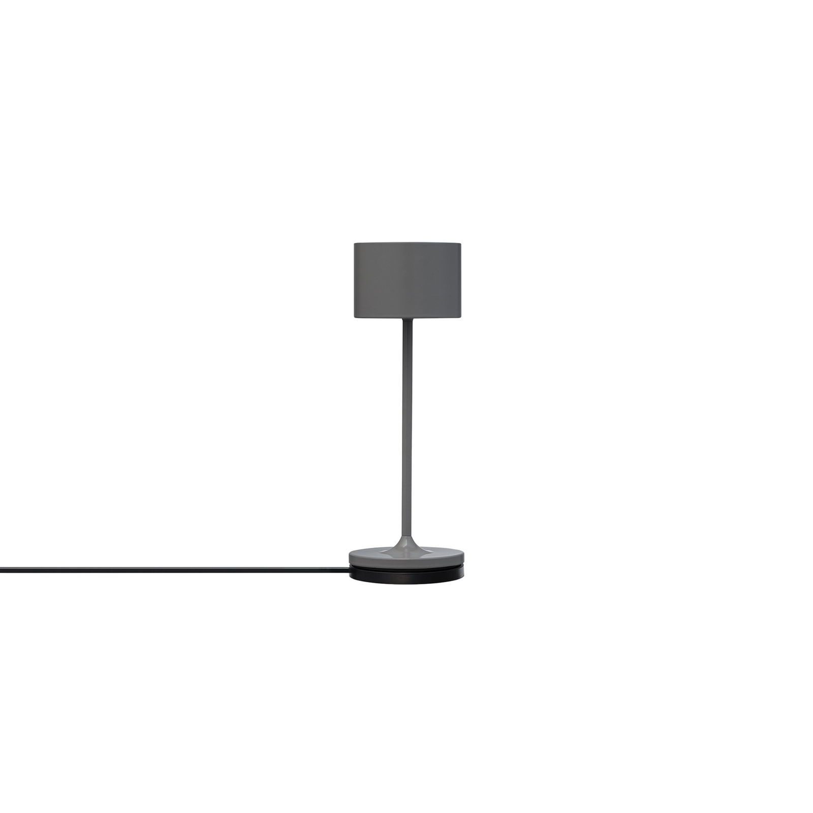 Minimalistische graue Tischlampe mit einem zylindrischen Schirm und schwarzem Kabel auf einem weißen Hintergrund.