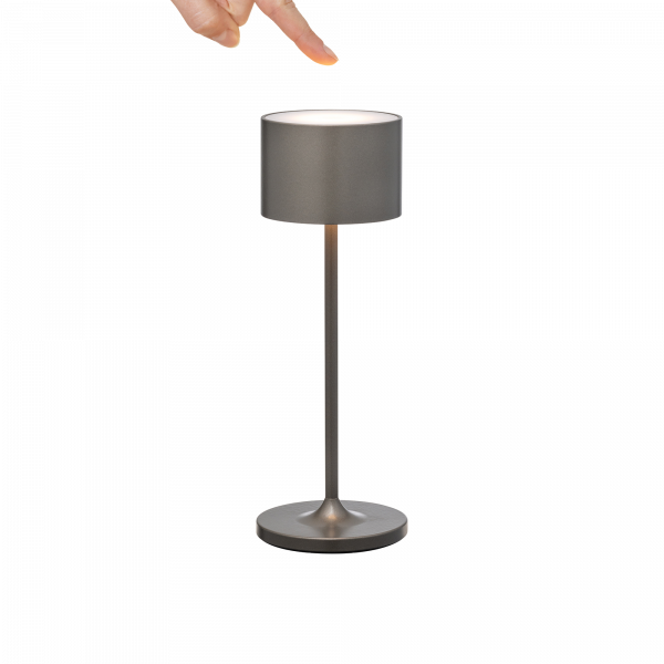 Moderne Silber Tischlampe mit einem Finger, der auf den Schirm zeigt.