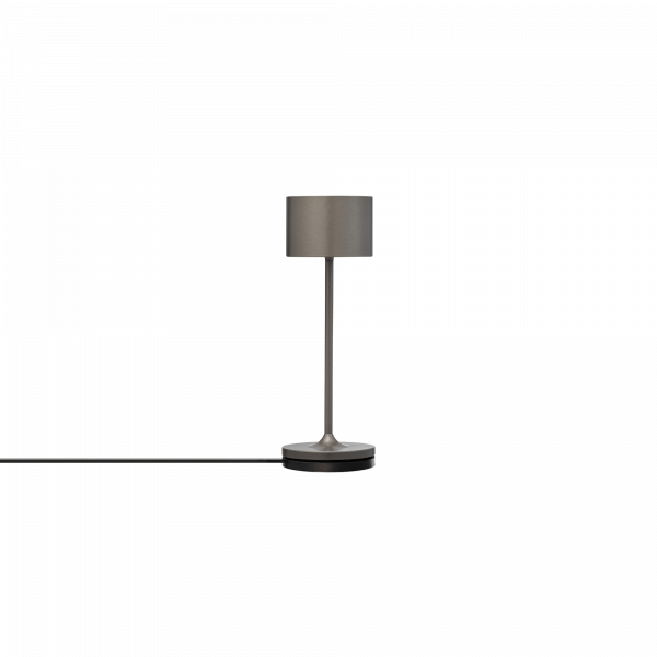 Moderne Tischlampe mit schlankem Design und schwarzem Kabel auf weißem Hintergrund.
