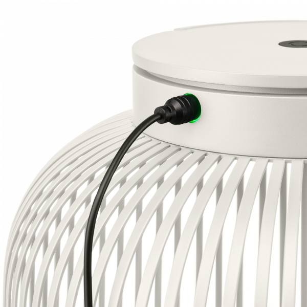 Weiße moderne Lampe mit einem grünen Ladeindikator und einem eingesteckten schwarzen Stromkabel.