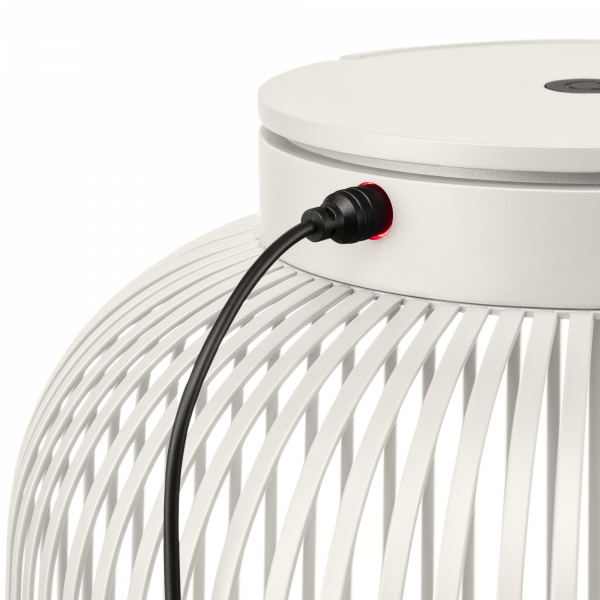 Nahaufnahme einer modernen weißen Lampe mit einem sichtbaren Stromkabel und einem roten Anzeigeleuchte.