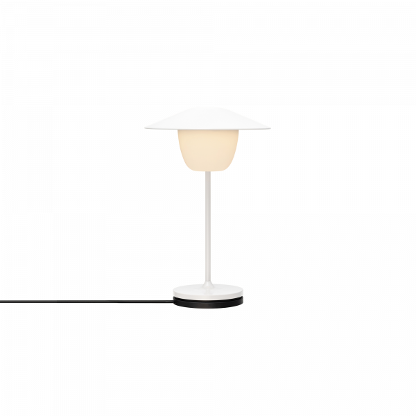 Moderne weiße Tischlampe mit einem stilvollen Lampenschirm und sanftem Lichtschein.
