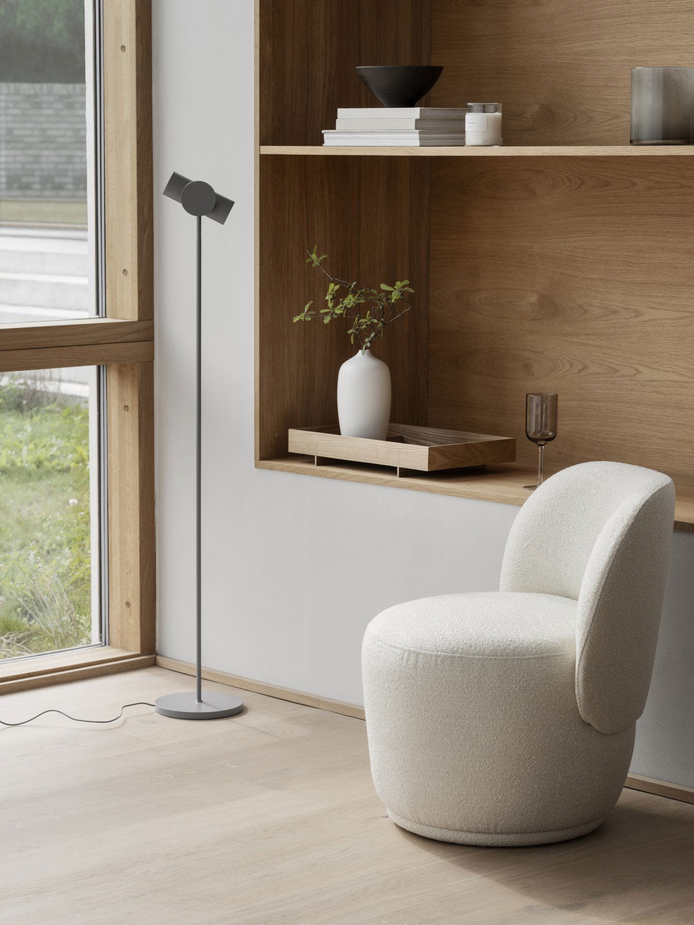 Modern living room featuring a stylish floor lamp and a cozy, textured white chair.