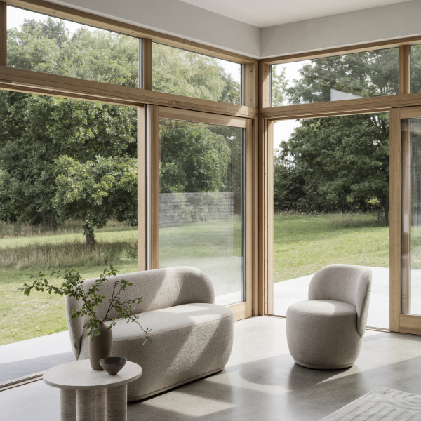 Modernes Wohnzimmer mit minimalistischer Möbeln und großen Fenstern, die einen Blick auf eine üppige grüne Landschaft bieten.