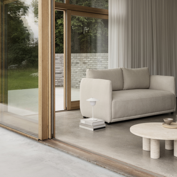 Moderner Wohnraum mit einem minimalistischen Sofa, einem Couchtisch und eleganter Innenbeleuchtung.