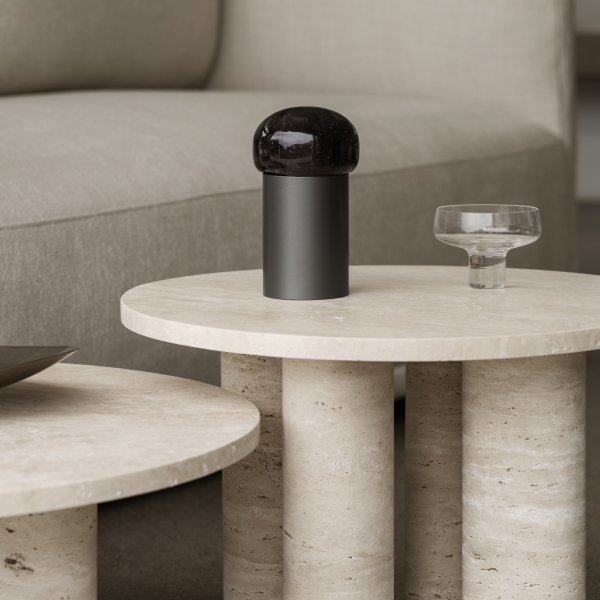 Moderne Kaffeetischdekoration mit einer stilvollen schwarzen Kuppellampe und einer eleganten Glasschüssel.
