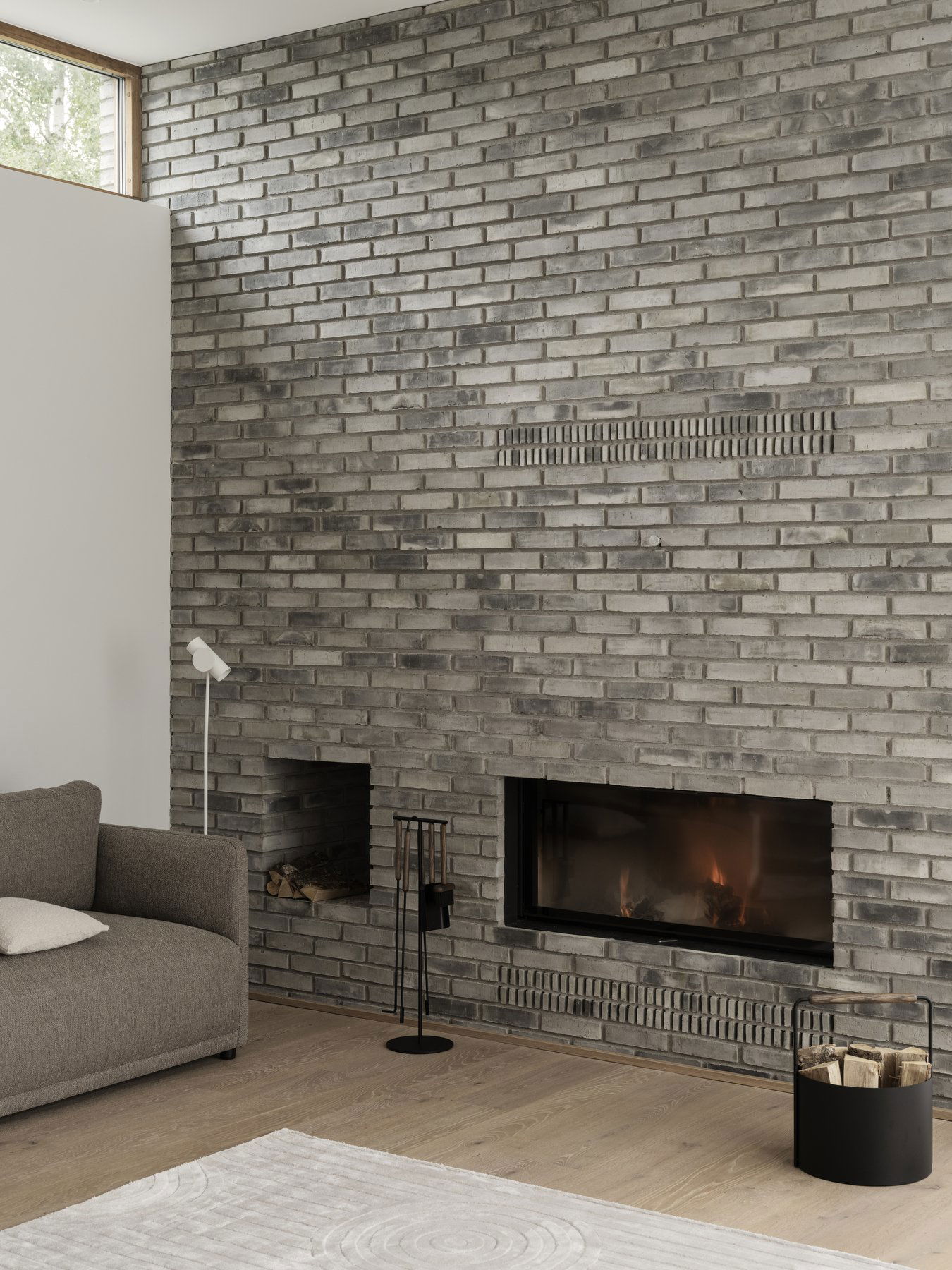 Modernes Wohnzimmer mit einem eleganten grauen Backsteinofen und minimalistischer Möbel.