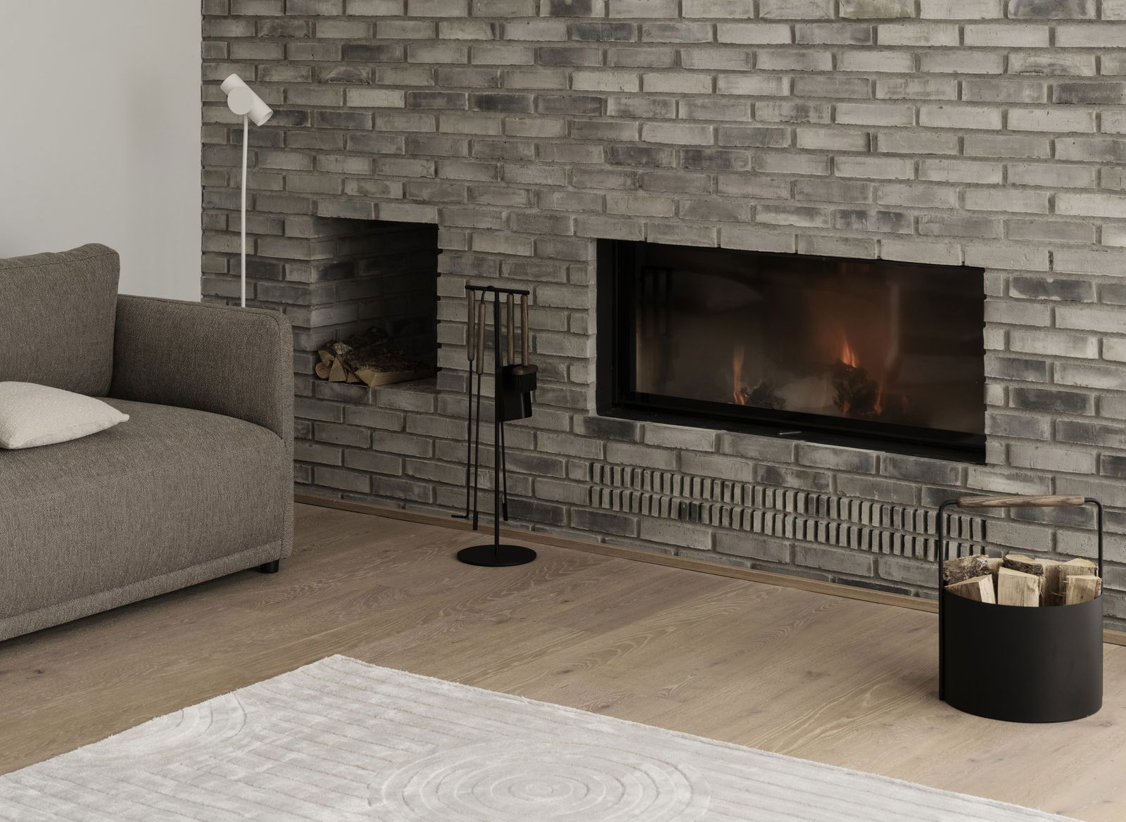 Modernes Wohnzimmer mit einem grauen Backstein-Kamin und gemütlicher Einrichtung für eine warme Atmosphäre.